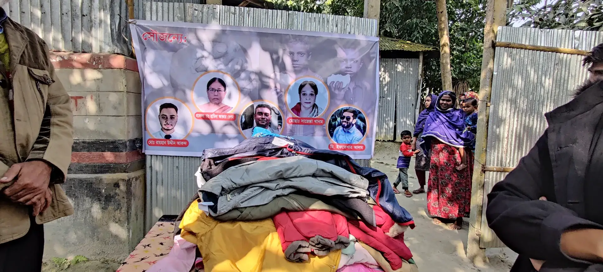 Piles of warm clothes ready to be handed out, with villagers waiting nearby.